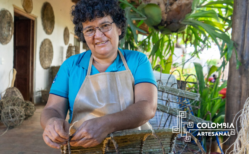 Foto de artesana del taller Canastos Don Nico tejiendo un canasto