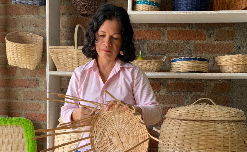 Foto de la artesana Zoraida Collazos tejiendo un canasto con fibra de guadua