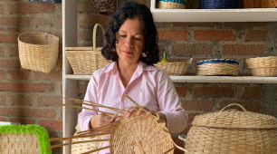 Foto de la artesana Zoraida Collazos tejiendo un canasto con fibra de guadua