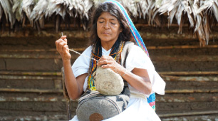 Foto de una artesana del Pueblo Arhuaco tejiendo una mochila