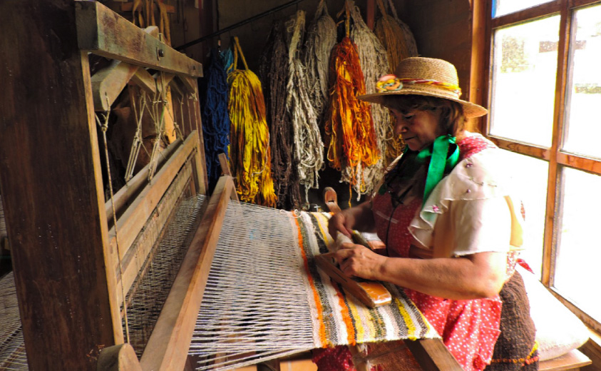Foto de artesana boyacense tejiendo lana en telar