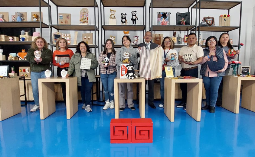 Un grupo de artesanos reunidos exhibiendo sus artesanías 