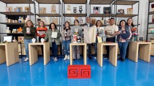 Un grupo de artesanos reunidos exhibiendo sus artesanías 